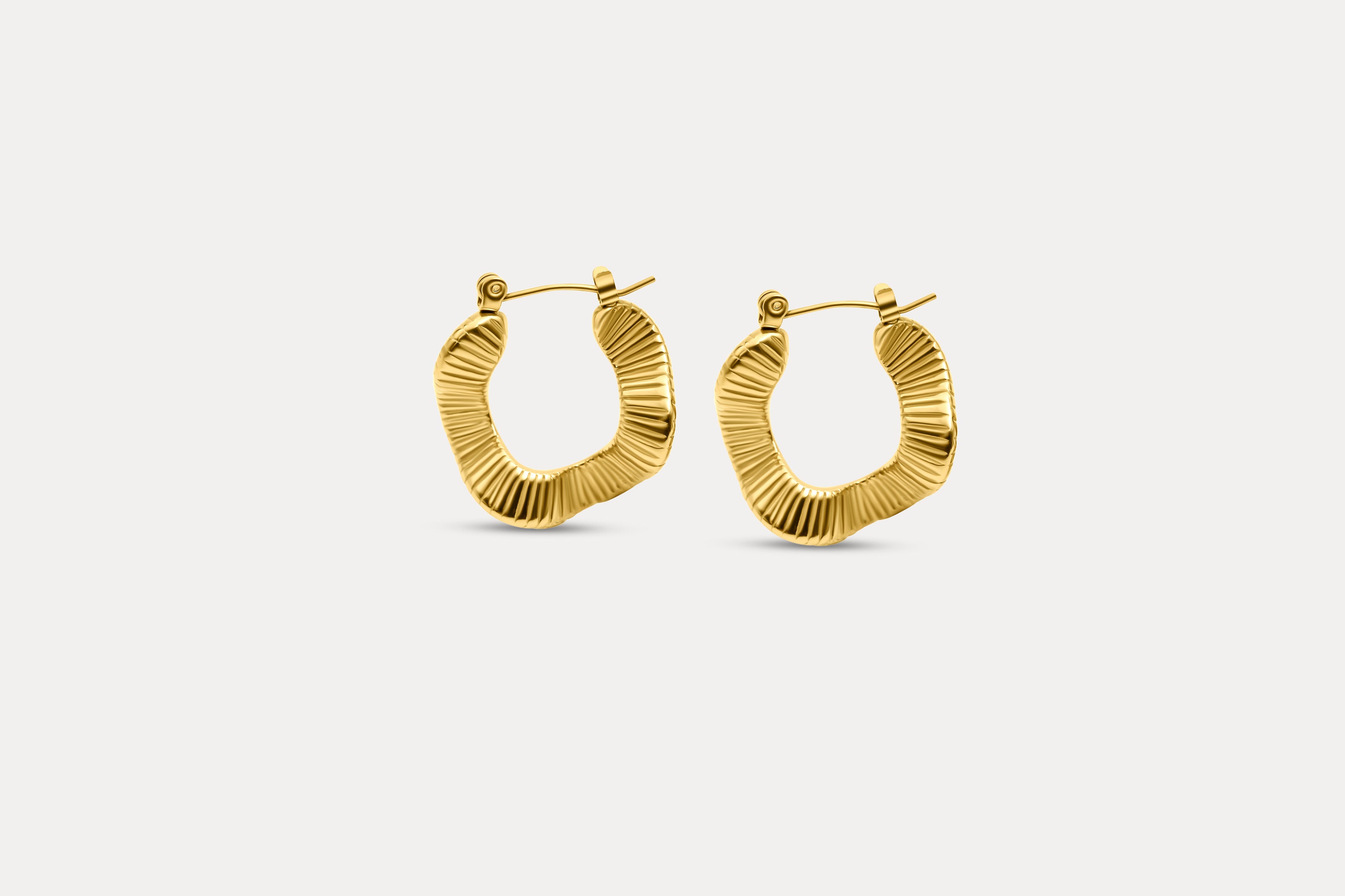 Gold textured hoop earrings with ridged oval profile and clasp back