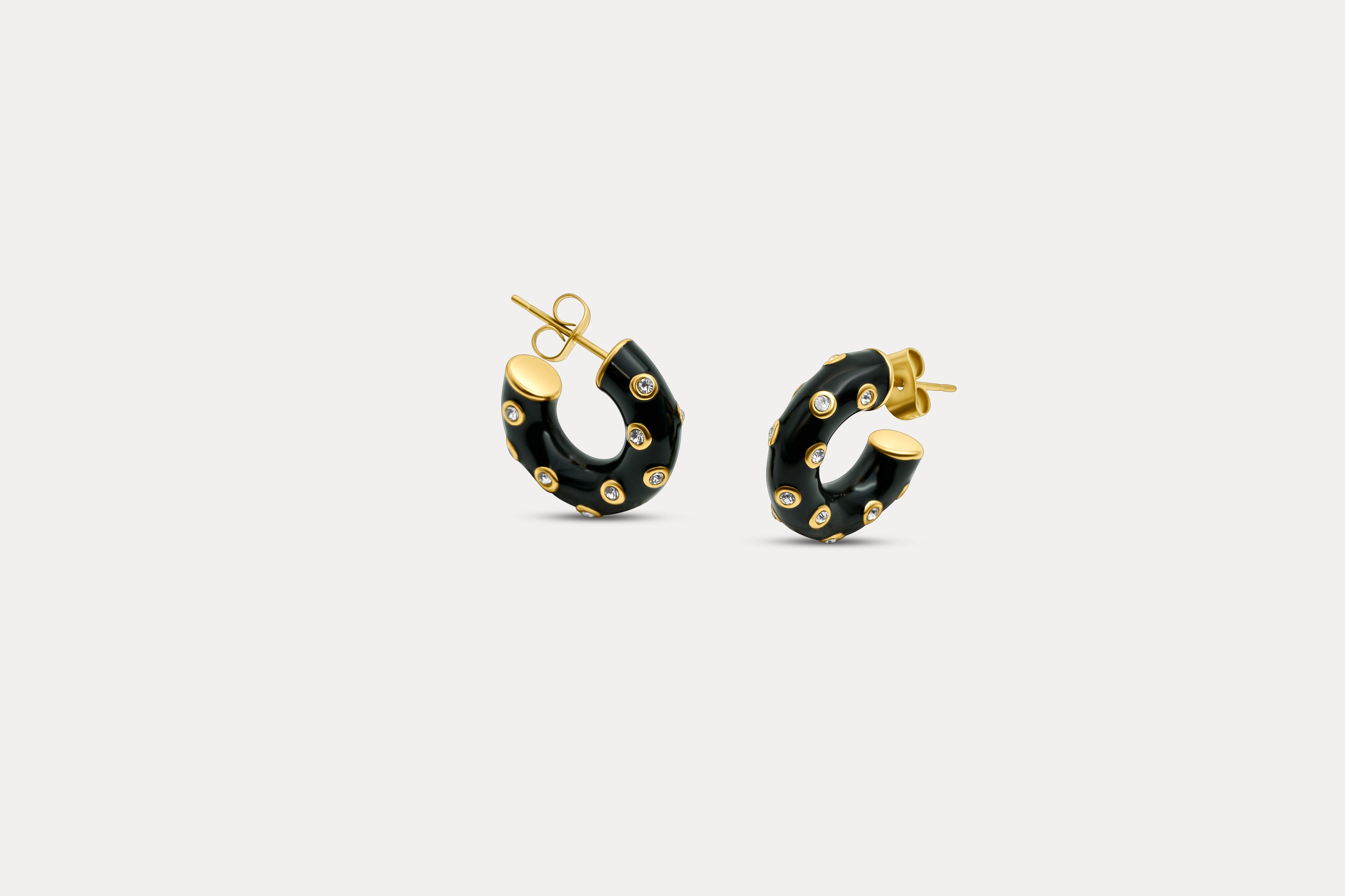 Gold-tone hoop earrings with black enamel and blue zirconia accents, round design.