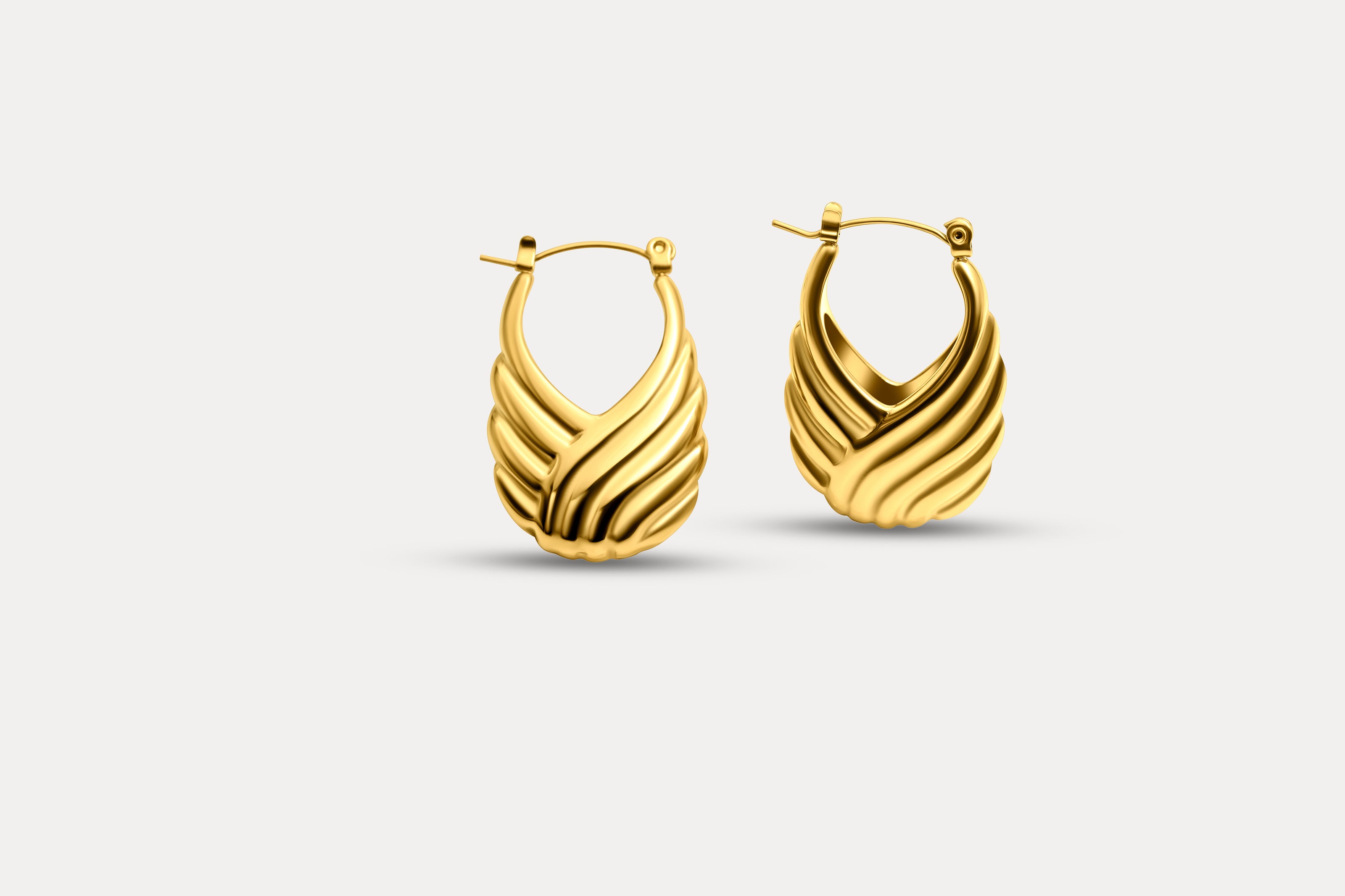 Pair of gold wave sculpted hoop earrings with ribbed swirl texture