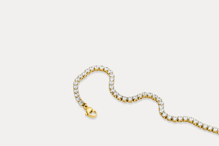 Gold tennis bracelet with clear rhinestone links and gold clasp, flat lay