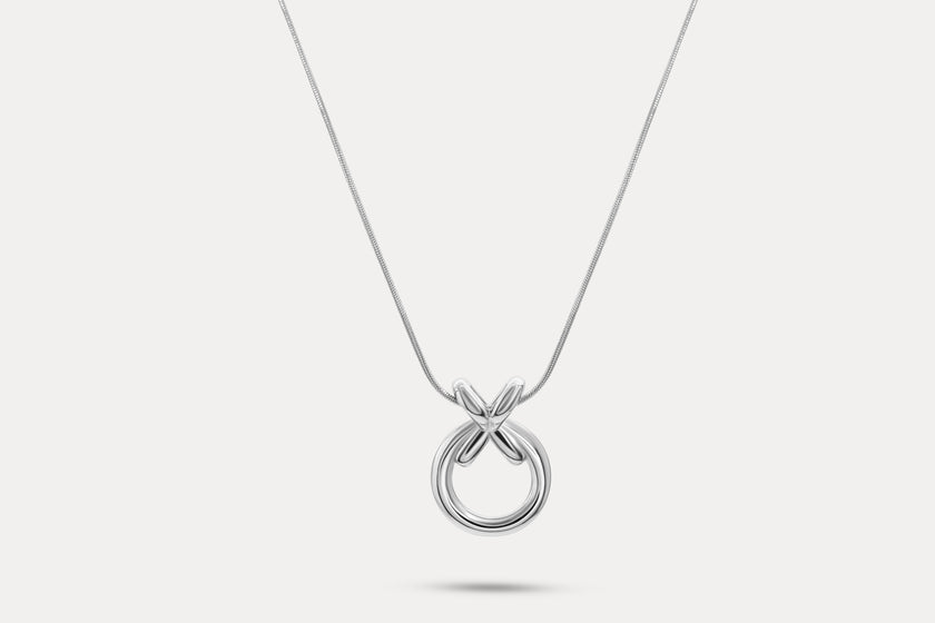 Circle pendant necklace with silver-tone round charm and linked X detail
