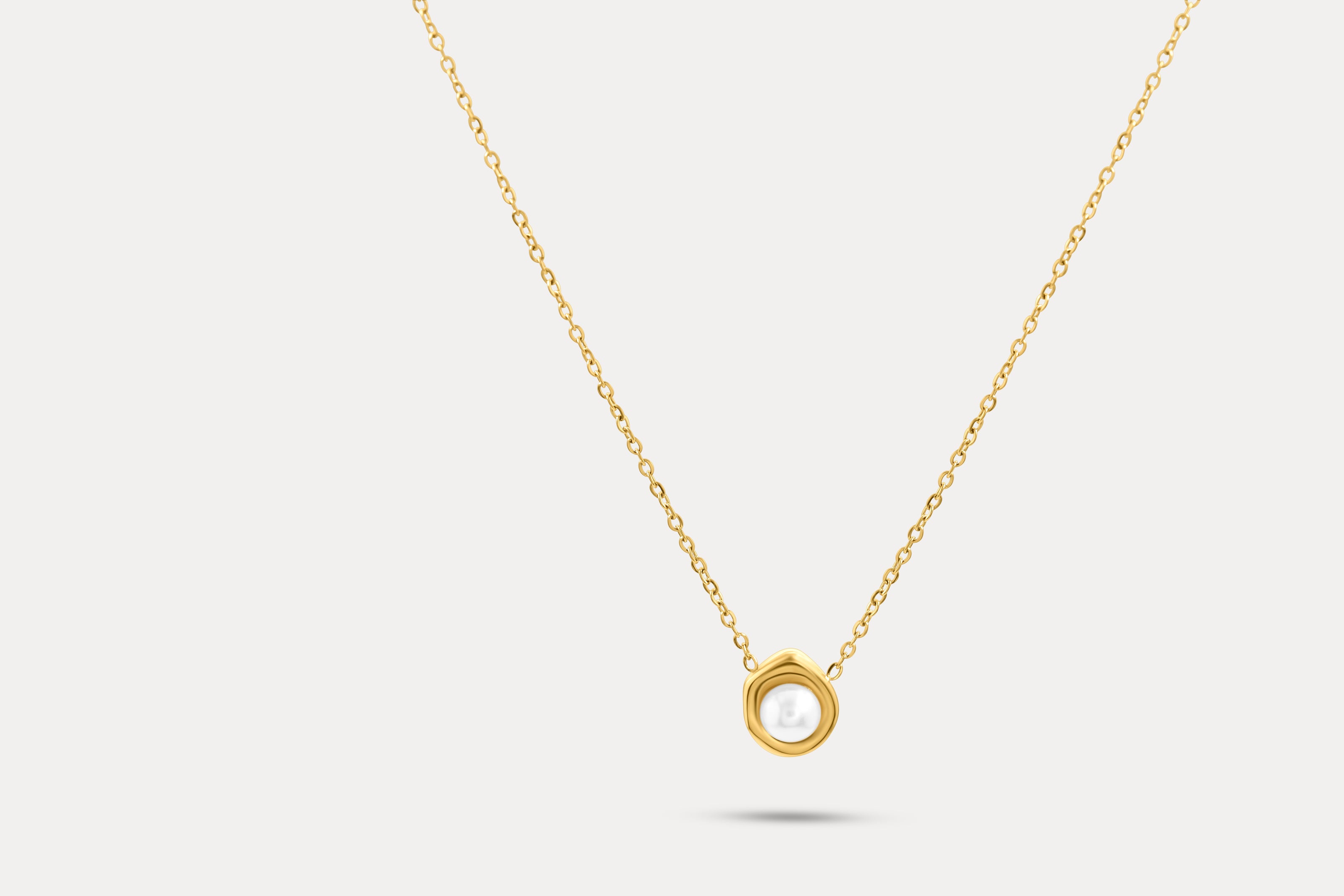 Gold pearl frame necklace with circular pendant on a fine chain