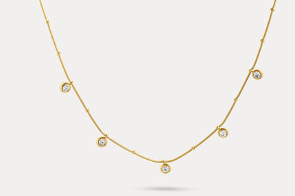Gold charm necklace with evenly spaced round blue stone charms
