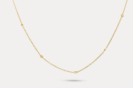 Gold chain necklace with tiny round crystal accents spaced along the length