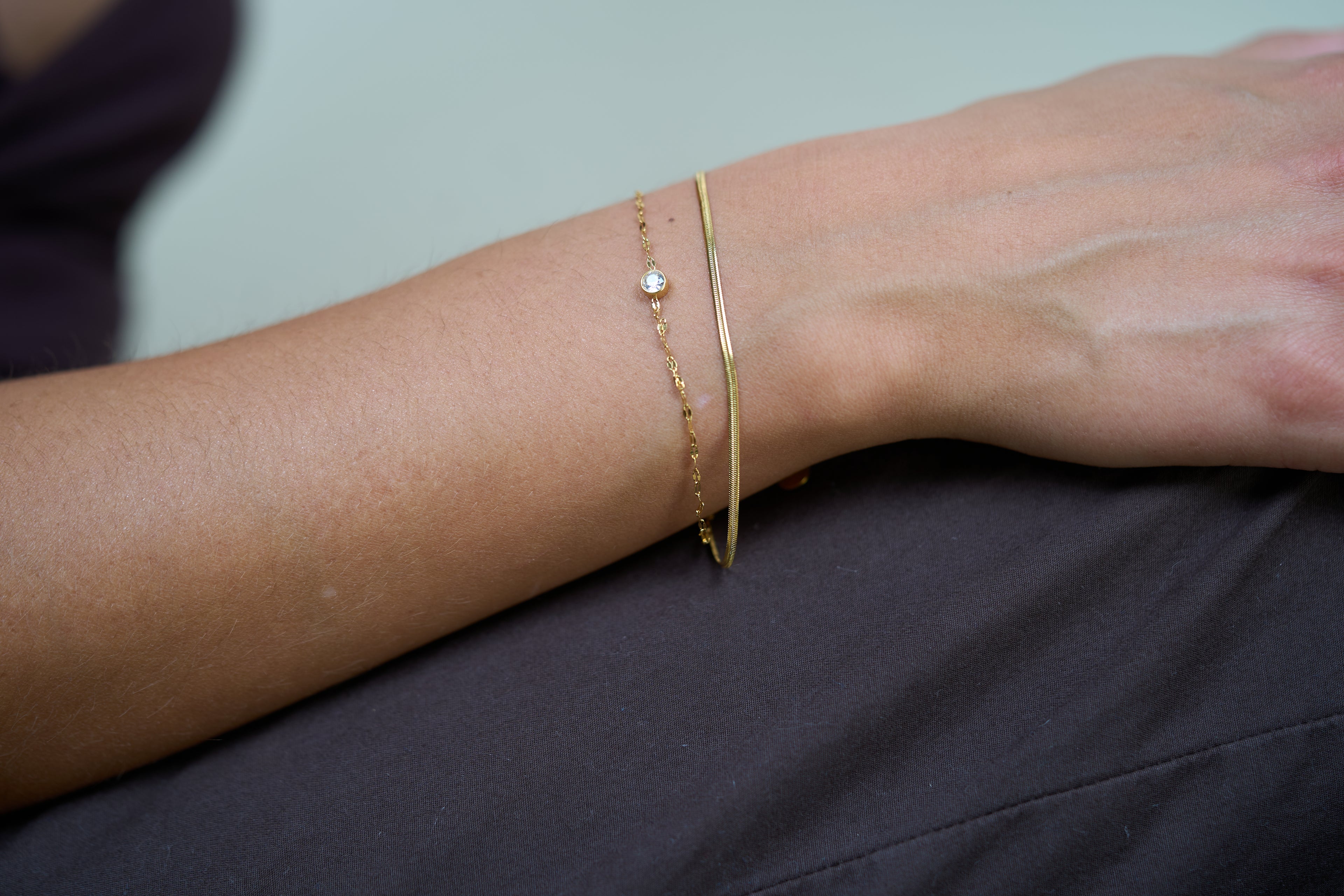 Gold double chain bracelet with small round gemstone charm