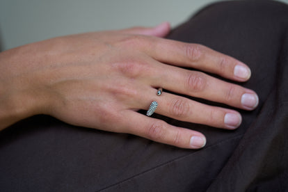 Silver crystal curve ring worn on finger, pavé stone detail